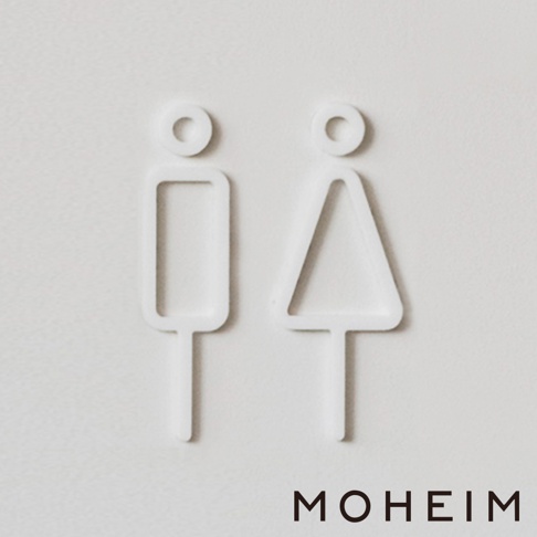 白色立體壓克力材質的男女廁所標示牌，分別以簡約的方形與三角形圖示代表。