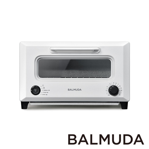 白色 ReBaker 烤麵包機，配有銀色提把、黑色旋鈕和玻璃視窗，機身印有 BALMUDA 品牌標誌。