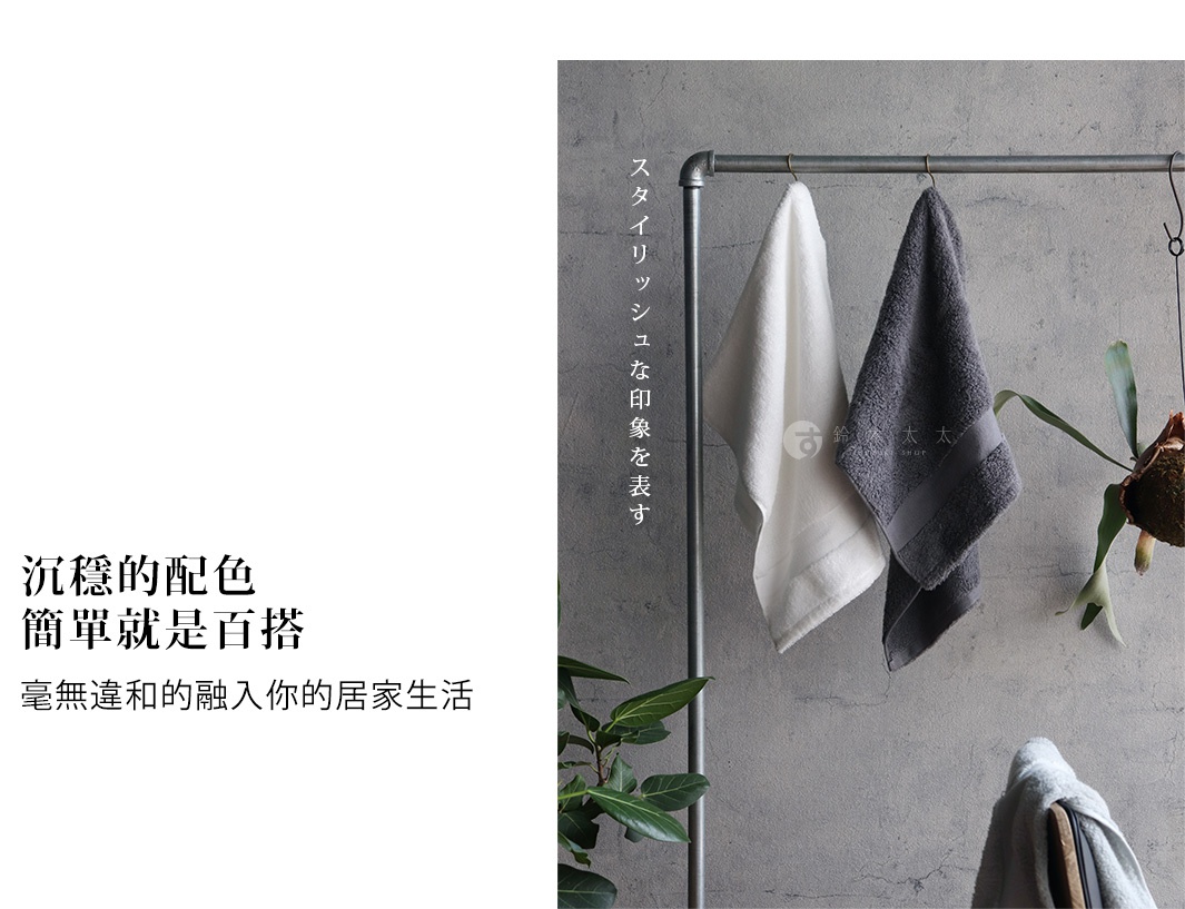 今治匹馬棉浴巾，展示白色與炭灰色兩色，材質柔軟，掛在金屬掛架上，旁邊有綠葉裝飾。