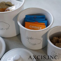 CAT&DOG 琺瑯儲物罐3入組，白色琺瑯材質，罐身繪有簡約的貓咪線條圖案。其中一個罐子內裝有藍色與橘色包裝的沖泡飲品。