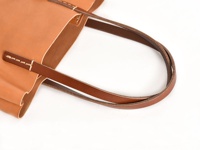 職人手作皮革直式軟皮托特包，採用淺棕色皮革製成，配有較深的棕色皮革提把，手工縫線細緻，展現簡約質感。