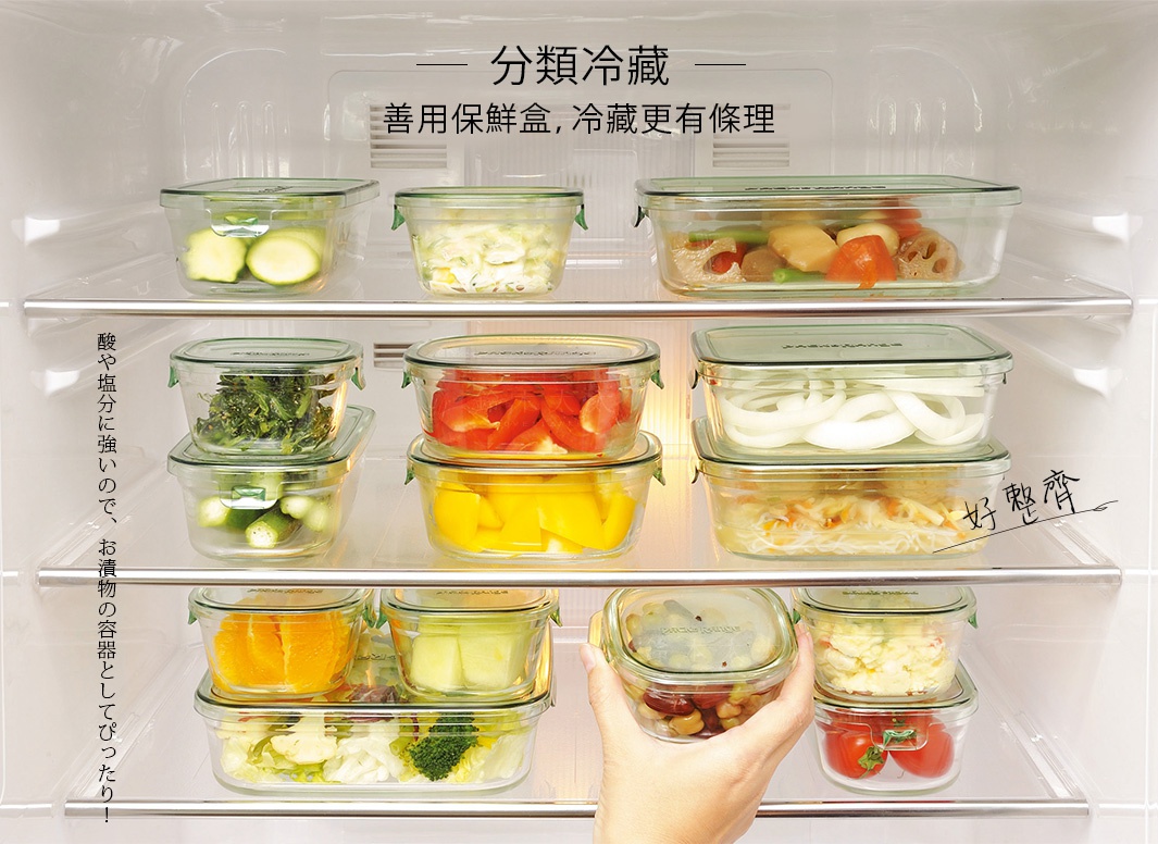 多個耐熱玻璃圓形和方形微波保鮮盒，帶綠色蓋子，內含各種食材，如黃瓜、沙拉、紅椒、黃椒、青菜、洋蔥、橘子、蘋果塊、豆類、番茄和蔬菜。