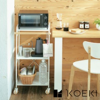 白色三層置物收納架，頂層擺放黑色烤箱，中層有黑色水壺、咖啡豆罐及餐巾，底層有藤編籃及寶特瓶，架子帶有輪子，整體材質為金屬與木材。