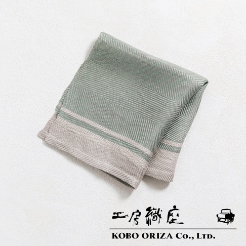 一塊淡綠色純亞麻斜紋萬用廚房拭巾，帶有米色邊緣和雙條線飾，材質為亞麻。