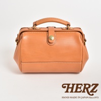 職人手作皮革口金醫生單肩包，採用天然棕色皮革，配有金色口金扣和縫線細節，設有手提把和可拆卸肩帶。