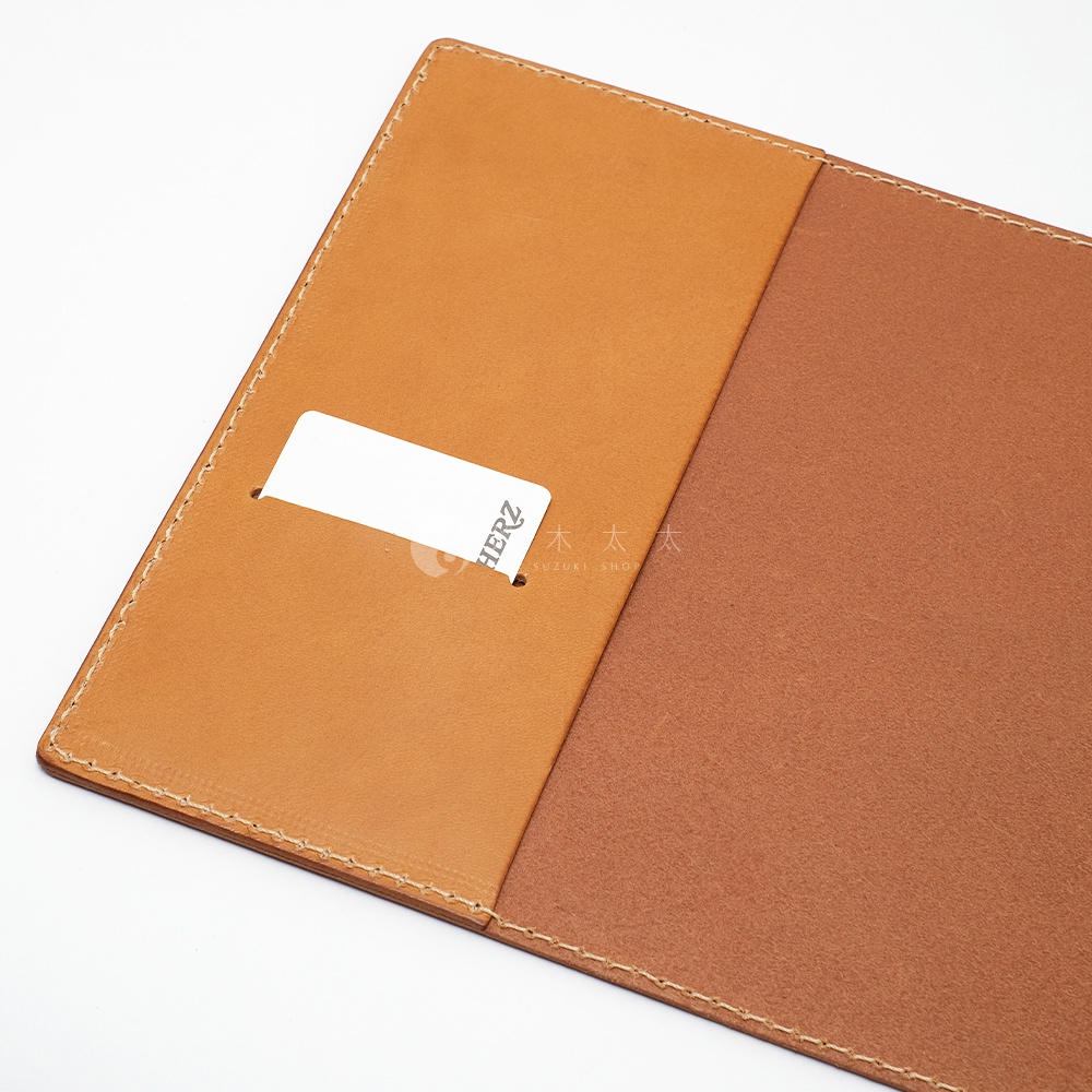 職人手作皮革B6記事本書套，採用兩種不同色澤的棕色皮革製成，包含一個卡槽，邊緣以縫線裝飾。