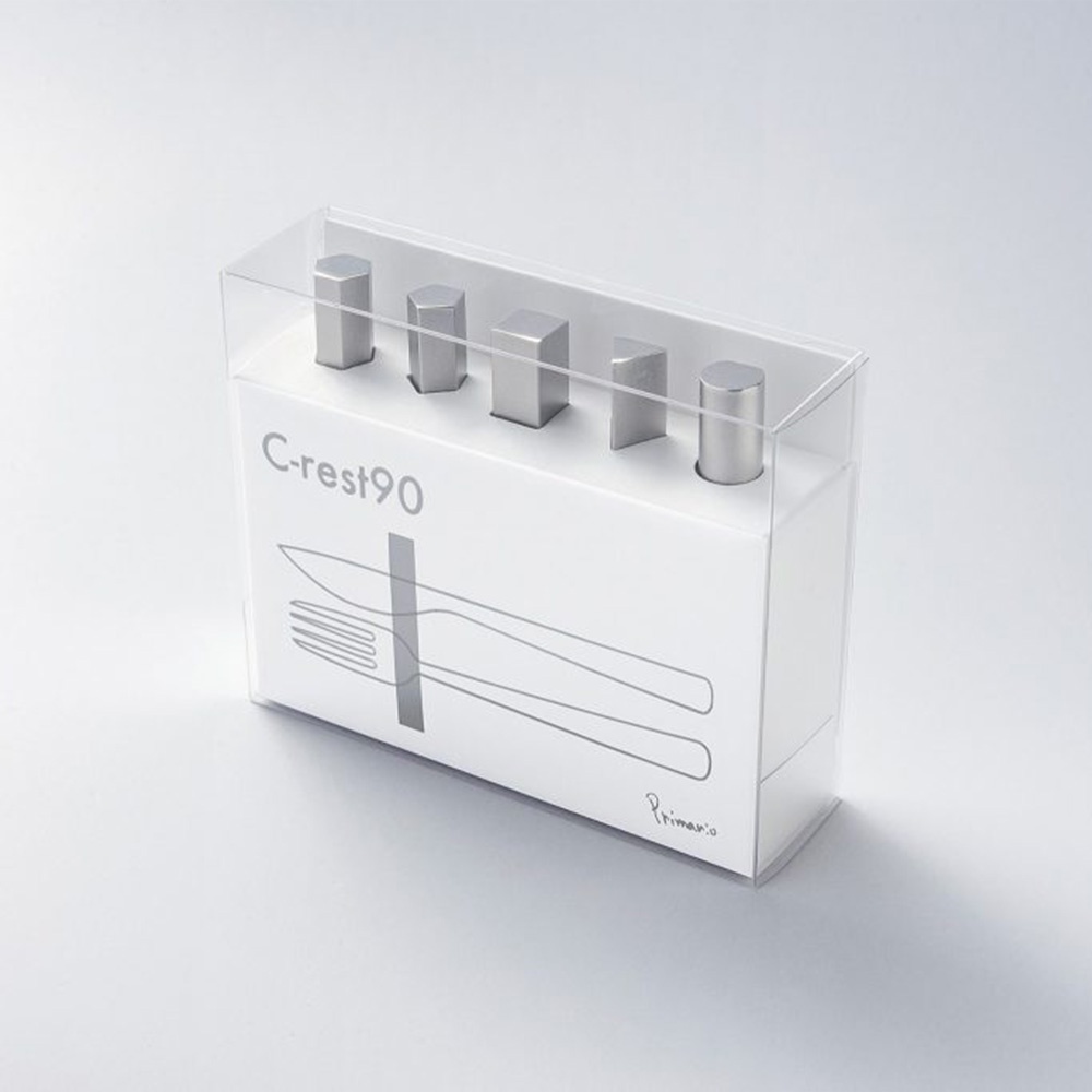 透明包裝盒內展示五個銀色金屬幾何造型筷架，每個筷架頂部呈不同幾何形狀（六邊形、方形、梯形、圓柱形），置於白色紙盒上，紙盒正面印有「C-rest90」字樣及餐具剪影圖案。