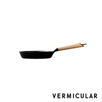 日本製黑色琺瑯鑄鐵平底鍋，配有淺木色木柄，鍋身呈現圓潤的弧度。