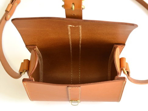 職人手作皮革皮扣單肩包，淺棕色，天然皮革材質，包蓋開啟，露出內部空間，一側有皮質提環和金屬扣環。