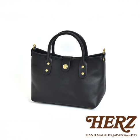 黑色皮革迷你托特包，設有金色旋轉鎖扣和金色鉚釘裝飾，簡約設計，適合日常攜帶。