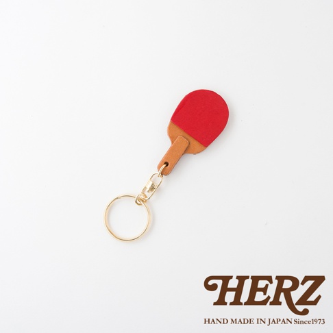 職人手作皮革桌球拍造型鑰匙圈，拍面為紅色，拍柄為棕色皮革，搭配金色鑰匙圈與掛鉤。