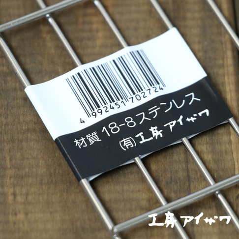 方形不鏽鋼瀝油架，採用 18-8 不鏽鋼材質，網格狀設計，有白色標籤貼紙，上面印有條碼和日文說明。