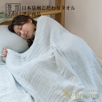 一位女性蓋著淺藍色四層紗毛巾毯，毛巾毯質地輕盈，呈現自然的皺褶感。