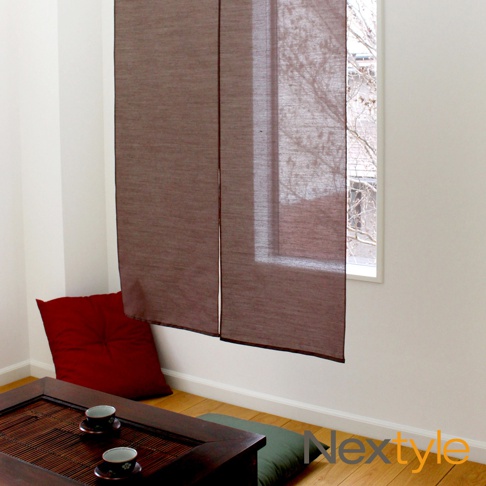 日製手作系京都懷舊防焰門簾，深棕色，棉麻混紡材質，兩片式設計，懸掛於白色牆壁與窗戶之間，窗外可見樹枝。