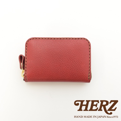 職人手作皮革收納錢包，酒紅色，採用荔枝紋皮革，配有金色拉鍊及皮革拉環，邊緣以深棕色縫線處理。