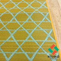 黃色榻榻米廚房地墊，表面有淺藍色交織的菱形網格圖案，材質為藺草編織，右側邊緣為黃色滾邊。