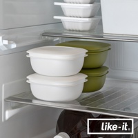 冰箱架上擺放著一組兩個白色簡約雙層蒸氣循環保鮮盒，堆疊整齊。右側還有兩組綠色同款保鮮盒。