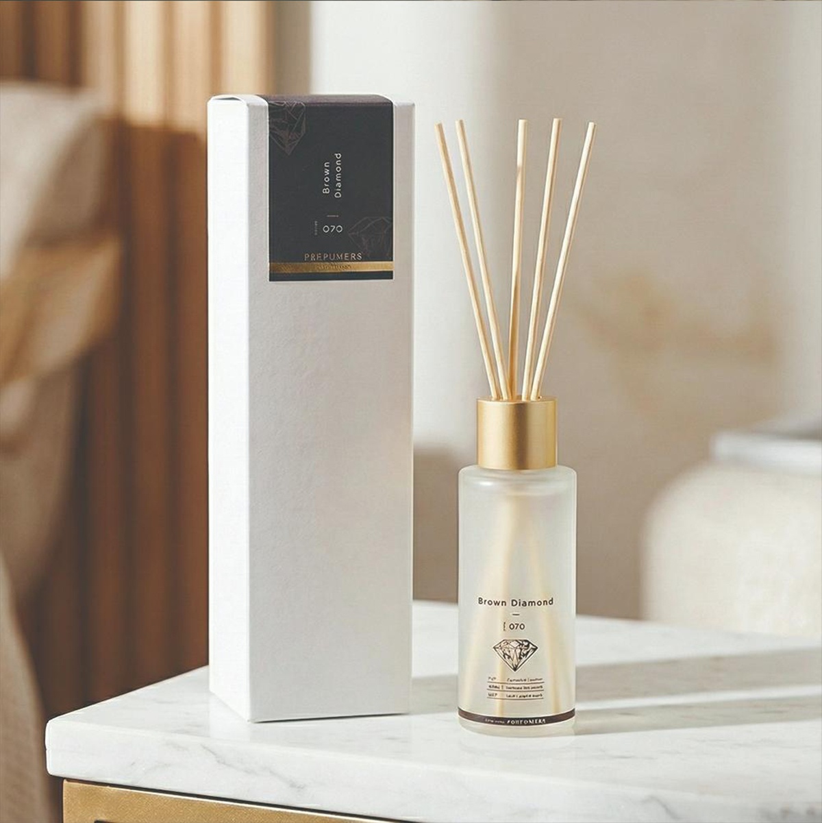 圖片中的白色長盒裝著一瓶帶有金色瓶蓋和擴香竹的擴香瓶，擴香瓶標籤上寫著「Brown Diamond 070」和一個鑽石圖案。