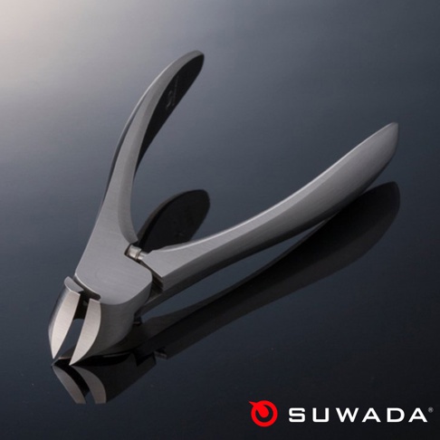 日本職人指甲剪-經典款 L，銀色不鏽鋼材質，帶有弧形手柄，刀刃處有開口，置於黑色光滑表面上，產品底部有 SUWADA 品牌標誌。