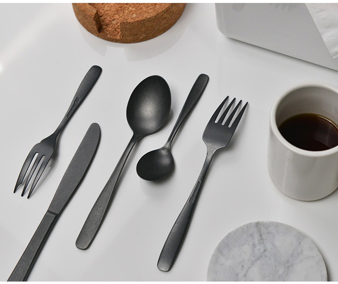 日製熔岩黑石餐刀組，包含一把餐刀、一把叉子、一把大湯匙及一把小湯匙，整體呈現霧面黑色金屬質感。