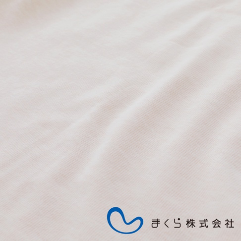 淺米色燈芯絨材質的良夢調節枕，表面有細緻的條紋和自然垂墜的皺褶，右下角有藍色曲線標誌與日文「まくら株式会社」字樣。