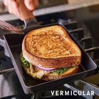 黑色琺瑯鑄鐵玉子燒平底鍋，方形鍋體，內有製作中的三明治，鍋蓋為木質手柄，烹飪中。