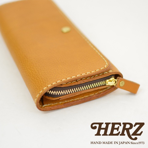 職人手作皮革長夾，淺棕色，寬口設計，搭配金色拉鍊與同色系皮革拉環，手工縫線清晰可見。