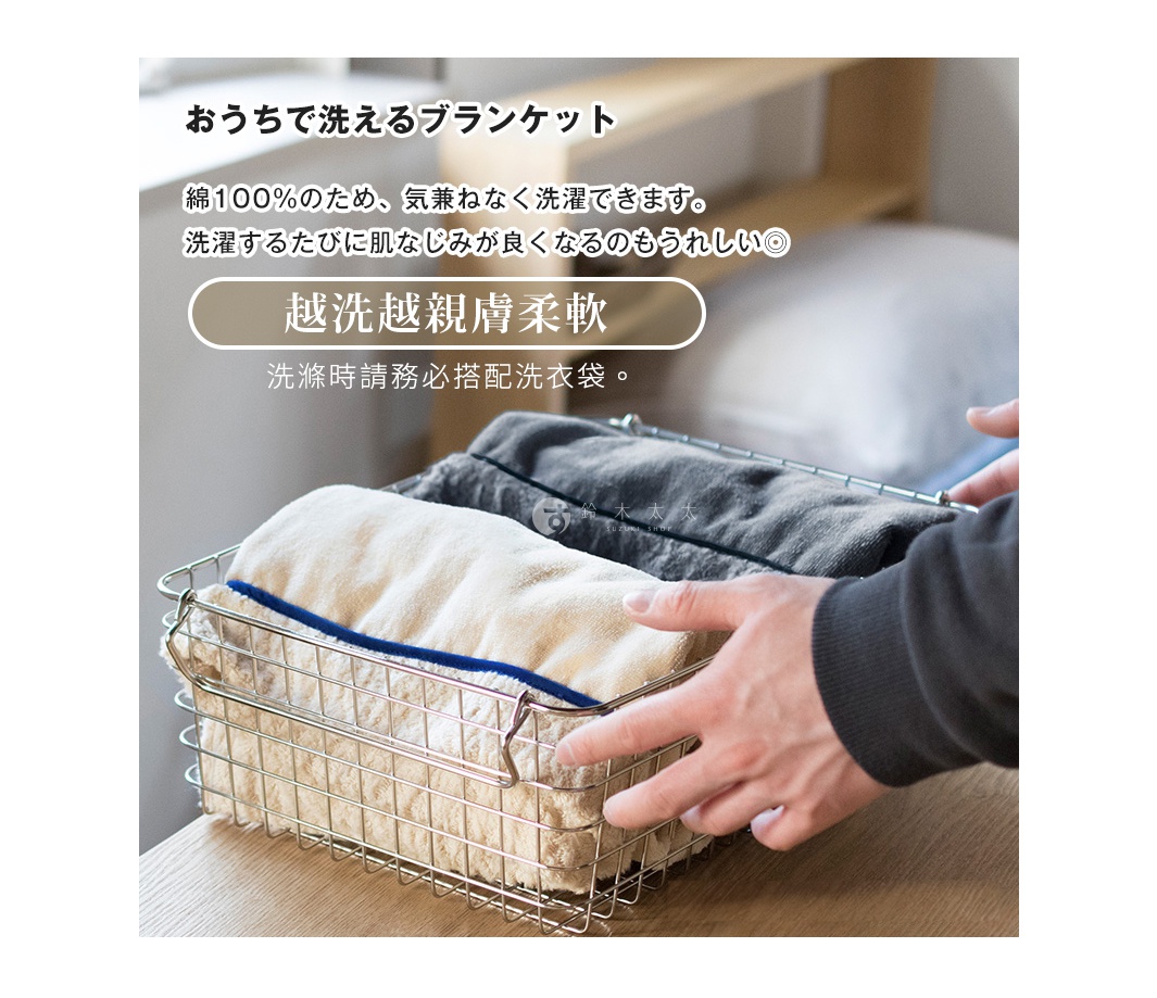 淺米色和深灰色羊毛感膝蓋毯，疊放在金屬置物籃中，有藍色滾邊。