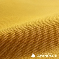 一塊黃色的帆布織物，呈現出粗糙的紋理，並帶有褶皺，右下角有「AYANOKOJI」的品牌標誌。