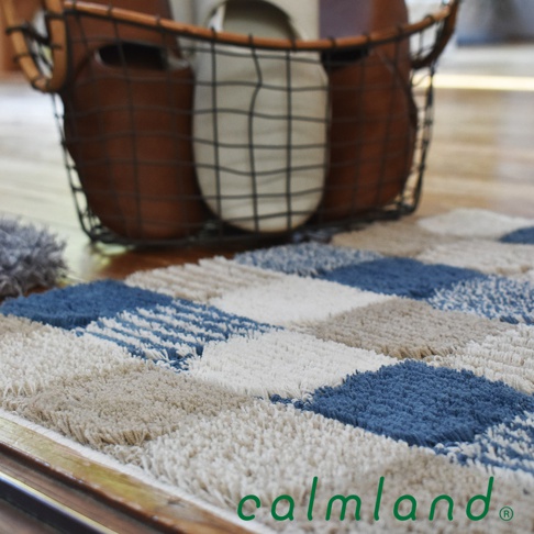 北歐風藝術居家地墊，採用菱格紋設計，以藍色、白色、米色和灰色塊拼接而成，材質柔軟，適合居家空間。