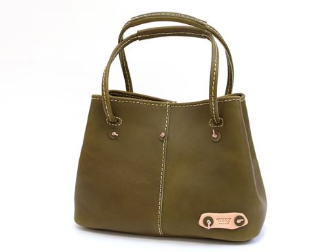 橄欖綠色皮革托特包，設有對比色的縫線、兩個頂部提把、側邊金屬扣以及一個皮革品牌標籤。