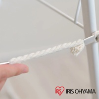 白色蝴蝶式曬衣架的細節，顯示一條白色編織繩索固定在金屬桿上，繩索末端有鬚狀處理。