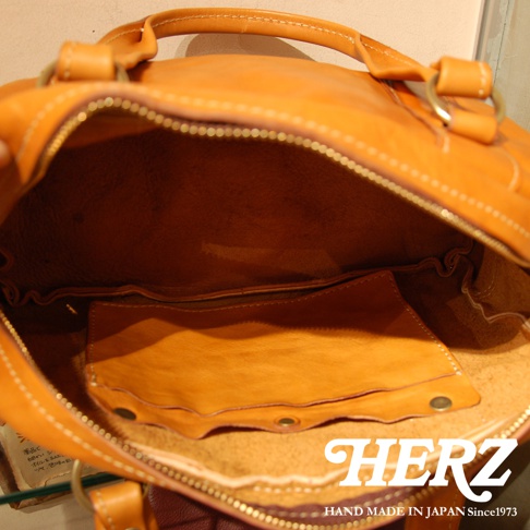 職人手作皮革水洗加工迷你波士頓包，呈現溫暖的焦糖色皮革，內裡為淺棕色皮革，設計有拉鍊開口及內部收納隔層。