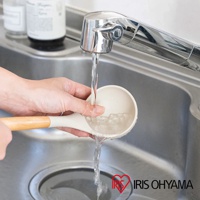 淺米色湯勺，搭配木質手柄，正在水槽下沖洗。