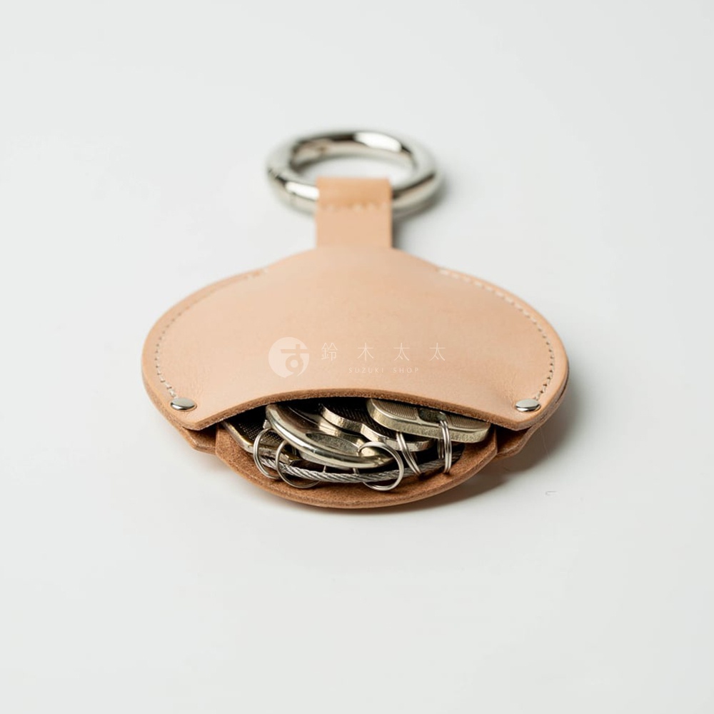 FABRIK 皮革圓形收納鑰匙圈，內含多枚日幣硬幣，附有金屬鑰匙環，整體色調為淺棕色。