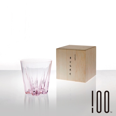 粉色玻璃威士忌杯，杯身帶有放射狀的立體切紋，搭配木質包裝盒，盒上印有日文「さくらさく」字樣。