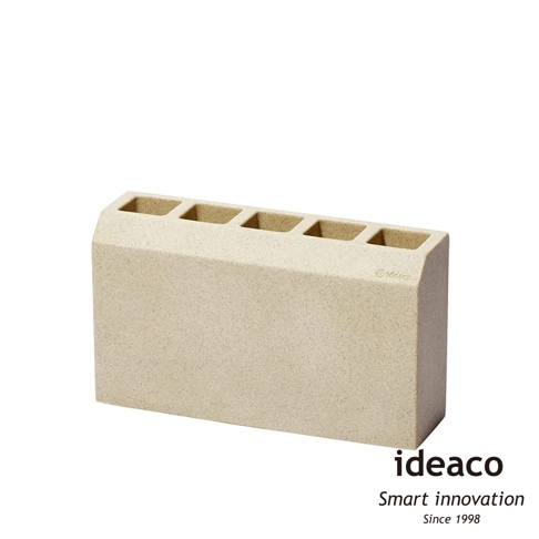 米色砂岩材質的門擋雨傘架，有五個收納孔，頂部邊緣呈弧形。