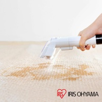 手持白色自動給水織物清潔機，噴出清潔液清潔淺米色地毯上的污漬。