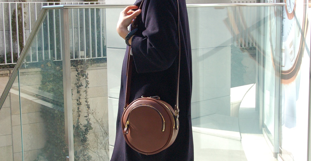 職人手作皮革小圓包 CK-19 M，咖啡色，圓形設計，附有金色拉鍊，肩背帶為同色系皮革。