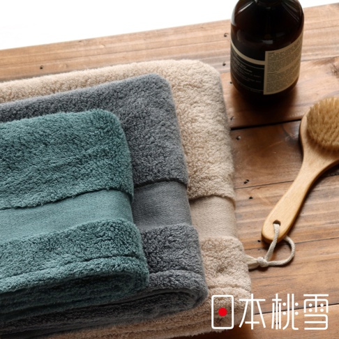 今治匹馬棉毛巾，疊放展示，包含水藍色、灰色及米白色三種顏色，毛巾質地蓬鬆柔軟，並有同色系較細緻的織帶裝飾。