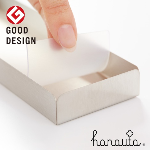 一個不鏽鋼餐具收納架，銀色，表面有細緻的髮絲紋。一隻手正將透明的隔板放入收納架內。