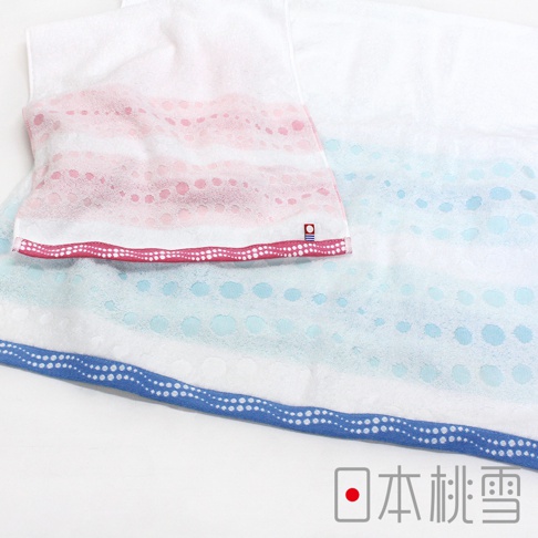 今治水泡泡毛巾，白色毛巾上印有粉色、淺藍色和白色漸層的圓點圖案，織紋細膩，觸感柔軟，邊緣飾有粉色和藍色滾邊，滾邊上點綴白色小圓點，毛巾上有品牌標籤。