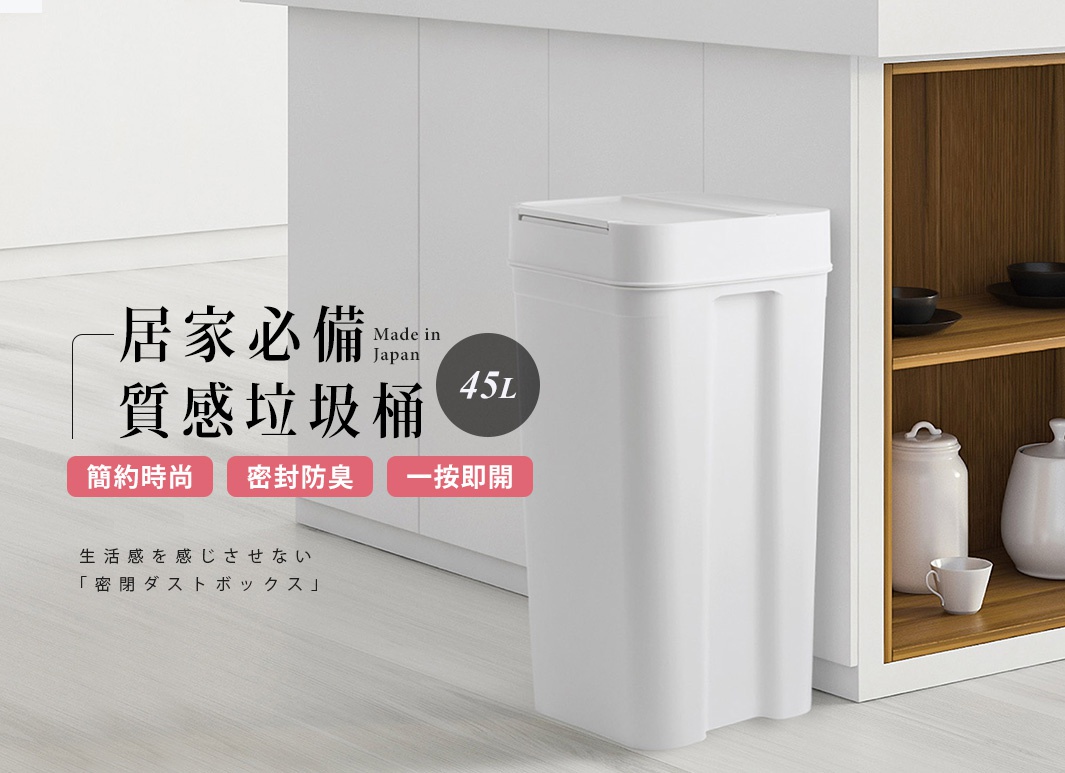 簡約時尚的白色 45L 密封防臭按壓式垃圾桶，側面有提把設計，放置於廚房櫃旁，與木質層架上的陶罐和茶杯形成對比。
