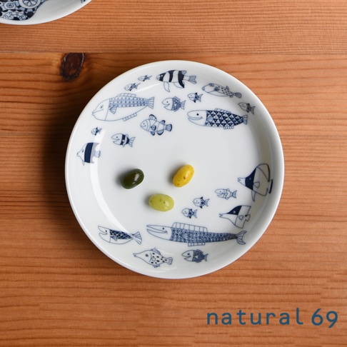 白色陶瓷小碟，佈滿藍色線條繪製的各種魚類圖案，碟中央擺放著三顆不同顏色的糖果。