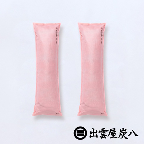 白色背景上並列放置兩包長條狀的粉紅色出雲屋炭八櫥櫃專用調濕木炭，袋身表面呈現細緻的不織布質感，右下角印有品牌名稱出雲屋炭八及其專屬圓形標誌。