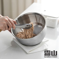 一個銀色304不鏽鋼斜底瀝水料理盆，盆內裝有蕎麥麵，由一雙金屬夾子夾起，下方墊著白色毛巾。