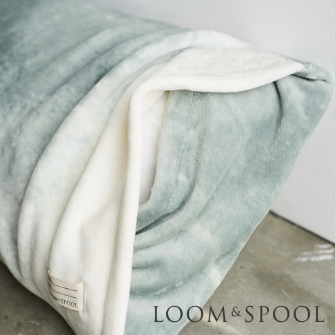 抗菌短絨舒柔枕套，灰綠色與米白色拼接，質地柔軟，一角有品牌標籤。