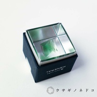 Sola cube 礦石立方塊，內含一塊綠色螢石，置於銀色金屬盒內，盒蓋為鏡面設計，映照出礦石的晶瑩剔透。