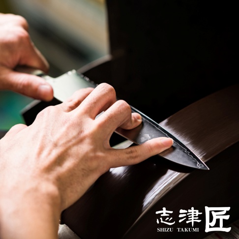 志津匠都 Petit knife 水果刀 13cm 的製作過程，職人正在仔細研磨刀刃。