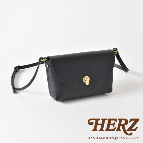 黑色皮革迷你單肩手袋，附有旋轉鎖扣和可調節肩帶。